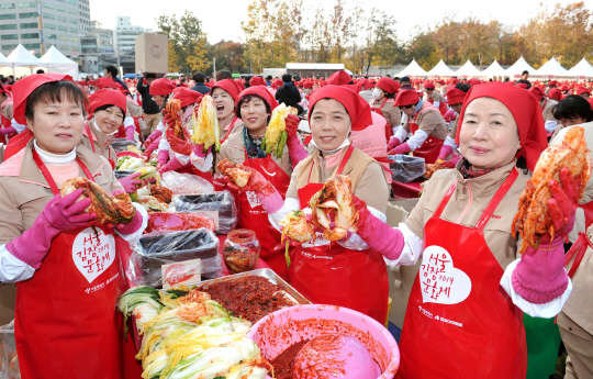 14일 오후 서울광장에서 열린 '2014 한국야쿠르트 사랑의 김장나누기 축제'에서 야쿠르트아줌마들이 김치를 담그고 있다. 이날 행사에서 담근 12만 포기의 김치는 홀몸노인 등 2만5천여 취약계층에 전달될 예정이다.  <한국야쿠르트 제공>